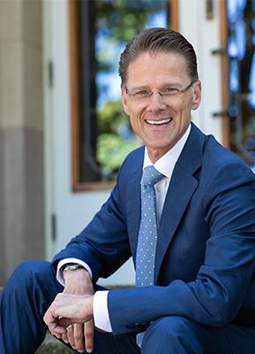 Seattle Pacific University's 10th president Daniel J. Martin sitting on the steps of McKinley Hall.